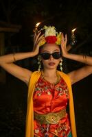 a portrait of an Indonesian dancer with jasmine dangling in her hair adorns her beautiful appearance on stage photo