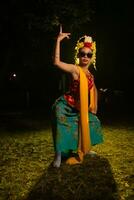 a Javanese dancer dances very skillfully while wearing sunglasses on her eyes and very beautiful facial makeup photo