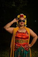 a portrait of an Indonesian dancer with jasmine dangling in her hair adorns her beautiful appearance on stage photo