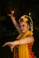 retrato de un indonesio bailarín con un oro cinturón bailando graciosamente foto