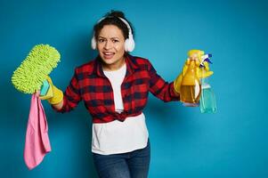 Angry African american woman cleaning products in hands looking at the camera bewildered before upcoming homework photo