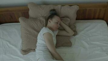 une femme dans blanc un pantalon est pose sur une lit video