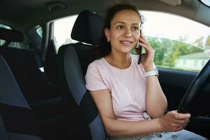 Young woman talking on the phone in the car during a stop photo