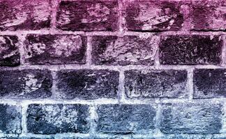 Brick wall interior background with purple and blue color light effect photo