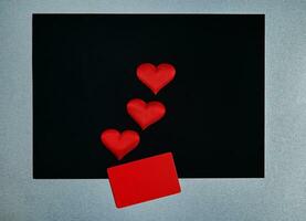 Red hearts, red rectangle on a black gray background. Border, copy space, top view, celebration, holiday photo
