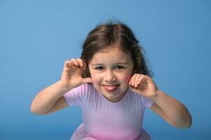 Face portrait of preschool girl grimacing looking at camera photo