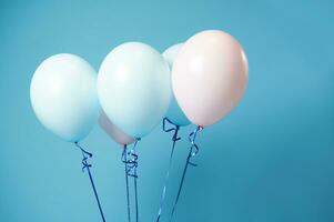 Closeup of pink and blue helium balloons on blue background with copy space. photo