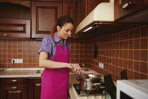 Heating and melting chocolate in a water bath before tempering it for preparing hand made chocolate desserts photo