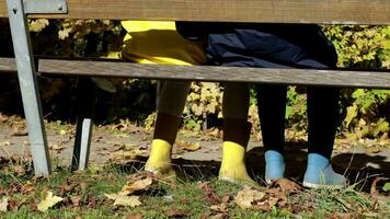 two children sit on a bench in the park video