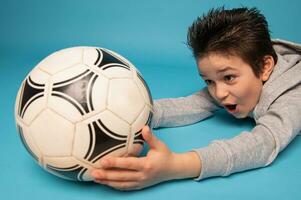 de cerca de un Adolescente chico, portero, atrapando un fútbol pelota foto