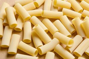 Pasta pattern. High angle view of a heap of uncooked whole wheat tortiglioni italian pasta. Food background photo