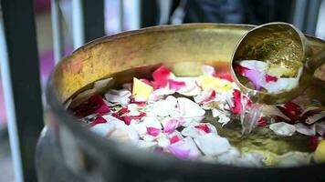 The ritual ahead of the wedding day is called flower bathing. stir the flower water in the water video