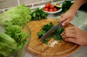 cocinando. comida y concepto de veganismo, vigor y sano comiendo - cerca arriba de hembra mano corte vegetales y Espinacas hojas para ensalada foto