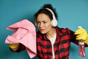 Focused woman simulating cleaning invisible surface with a cleaning rag and a spray with detergent. photo