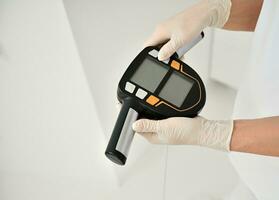 Close-up. Top view of physiotherapist, doctor's hands in sterile surgical gloves holding medical smart scales for determining the weight and biological age of spa clients photo