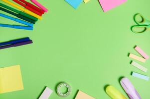 plano laico composición con papelería oficina o colegio suministros dispersado en un circulo en un ligero verde antecedentes con Copiar espacio. del maestro día concepto foto