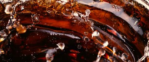 Splashing of Cola and Ice. Cola soda and ice splashing fizzing or floating up to top of surface. Close up of ice in cola water. Texture of carbonate drink with bubbles in glass. Cold drink background photo