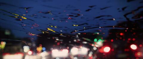 Driving in raining. Rain on car windshield or car window in rainy season and blurry traffic road in background. Rain drops on car mirror. Road in rain. Drizzle raining decreases driving visibility. photo