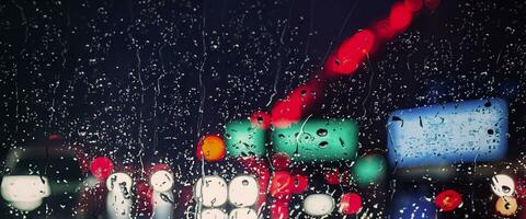Driving in raining. Rain on car windshield or car window in rainy season and blurry traffic road in background. Rain drops on car mirror. Road in rain. Drizzle raining decreases driving visibility. photo