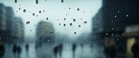 Rain drop on window glass of coffee shop and blurry city life background. Rainy season and blurry people city day life or bokeh night lights outside window. Coffee shop window covered with rain water photo