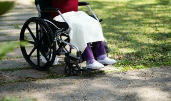 enfermería hogar. joven cuidador Ayudar mayor mujer en silla de ruedas. foto