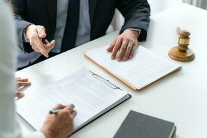 Lawyer Legal counsel presents to the client a signed contract with gavel and legal law. justice and lawyer Business partnership meeting concept. photo