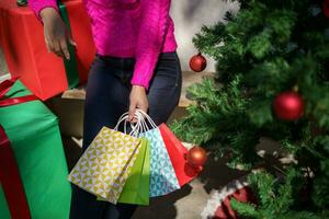 Happy asian girl hold shopping bags Xmas present. cheerful woman with Christmas New Year Winter sale photo