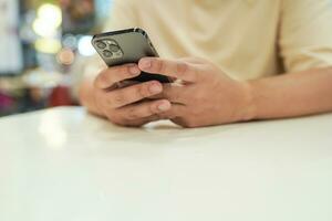 Relaxed young asian man using smart phone  spending time checking news social media. photo