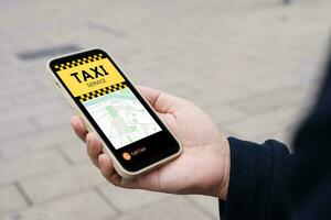 Man in downtown city street ordering taxi using smart phone app Booking taxi using application online on smart phone photo