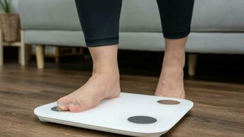 pies en pie en electrónico escamas para peso control. medición instrumento en kilogramo para un dieta controlar foto