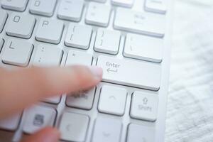 Hands of business woman Pressing enter button on computer keyboard photo