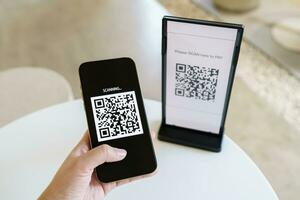 Qr code payment. E wallet. Man scanning tag accepted generate digital pay without money.scanning QR code online shopping cashless payment and verification technology concept. photo