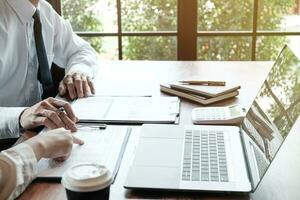 Businessman analyzing investment charts and pressing calculator buttons over documents. Accounting Concept. photo