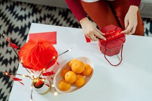 Asian Woman holding red gift box thankful present Lunar New Year. Chinese traditional holiday. Lunar new year culture. photo