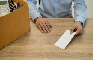 sending resignation letter to boss and Holding Stuff Resign Depress or carrying cardboard box by desk in office photo