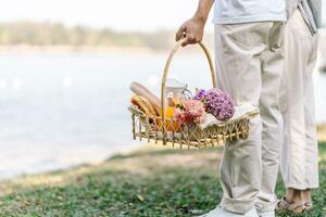 Couple walking in garden with picnic basket. in love couple is enjoying picnic time in park outdoors photo