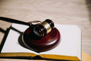 Justice and law concept.Male judge in a courtroom with the gavel, working with, computer and docking keyboard, eyeglasses, on table in morning light photo