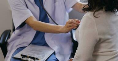 Homecare nursing service and elderly people cardiology healthcare. Close up of young hispanic female doctor nurse check mature caucasian man patient heartbeat using stethoscope during visit photo