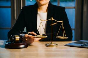 Justice and law concept.Male judge in a courtroom with the gavel, working with, computer and docking keyboard, eyeglasses, on table in morning light photo