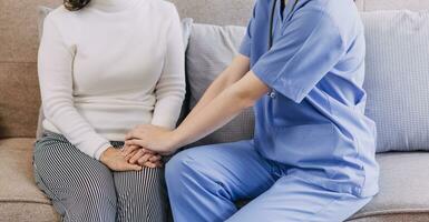 Homecare nursing service and elderly people cardiology healthcare. Close up of young hispanic female doctor nurse check mature caucasian man patient heartbeat using stethoscope during visit photo