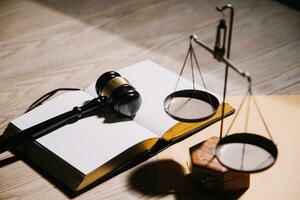 Justice and law concept.Male judge in a courtroom with the gavel, working with, computer and docking keyboard, eyeglasses, on table in morning light photo