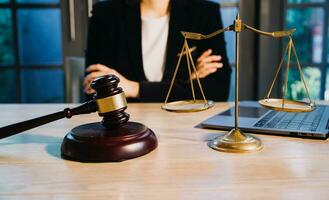 Justice and law concept.Male judge in a courtroom with the gavel, working with, computer and docking keyboard, eyeglasses, on table in morning light photo