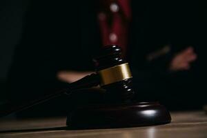 Justice and law concept.Male judge in a courtroom with the gavel, working with, computer and docking keyboard, eyeglasses, on table in morning light photo