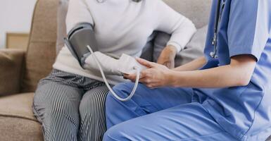 Homecare nursing service and elderly people cardiology healthcare. Close up of young hispanic female doctor nurse check mature caucasian man patient heartbeat using stethoscope during visit photo