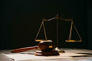 Justice and law concept.Male judge in a courtroom with the gavel, working with, computer and docking keyboard, eyeglasses, on table in morning light photo