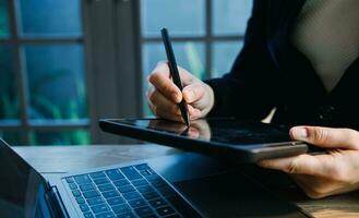 close up hands multitasking man using tablet, laptop and cellphone connecting wifi photo