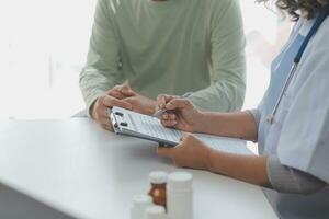 A health visitor with tablet explaining a senior woman how to take pills. photo