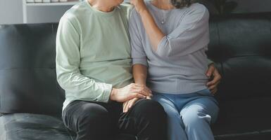 Embraced mature couple surfing the Internet on laptop at home photo