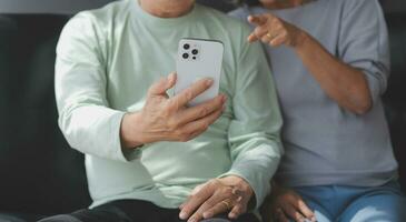 Embraced mature couple surfing the Internet on laptop at home photo