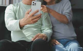 Embraced mature couple surfing the Internet on laptop at home photo